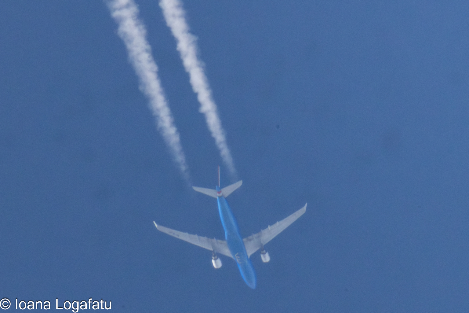 Contrails etch the sky as planes soar high above